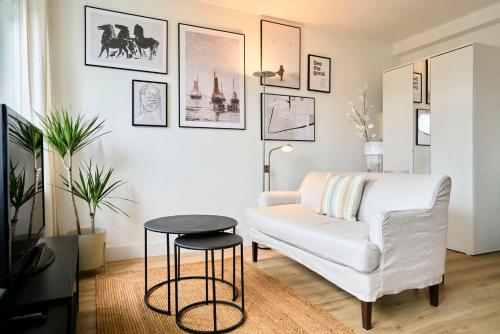 un salon avec un canapé blanc et une table dans l'établissement Appartement une chambre proche métro, à Lille