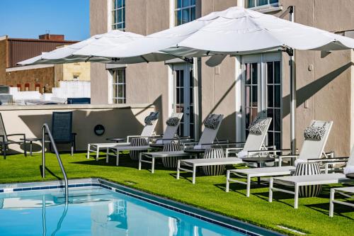 a group of chairs and umbrellas next to a pool at The Lindy Renaissance Charleston Hotel in Charleston