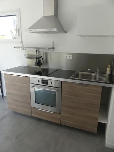 une cuisine avec une cuisinière et un évier dans l'établissement Rencontre terre et mer, à Bourgneuf-en-Retz