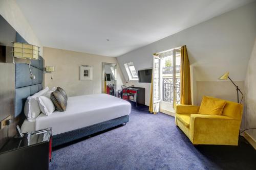a hotel room with a bed and a yellow chair at Chalgrin Boutique Hotel in Paris