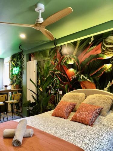 - une chambre avec une fresque murale représentant des plantes dans l'établissement Studio Jungle Climatisé, à Brive-la-Gaillarde