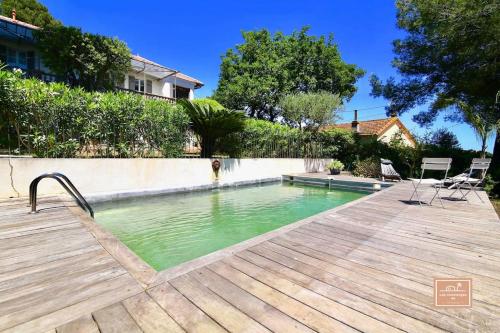 - une piscine dans une cour avec une terrasse en bois dans l'établissement Villa Yves et piscine privée, à La Seyne-sur-Mer