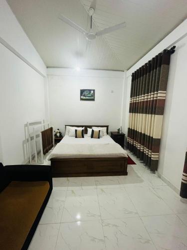 a bedroom with a bed and a ceiling fan at Kandy Home stay in Katugastota