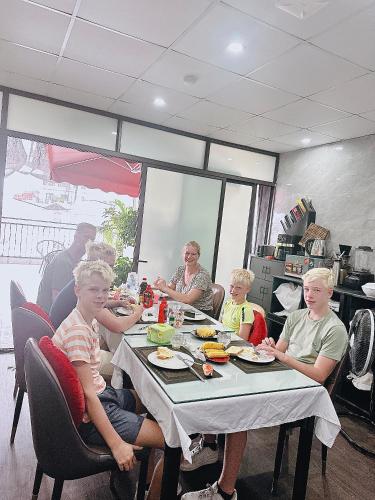 un gruppo di persone sedute a un tavolo che mangiano cibo di Golden Rose Premium Hotel Hanoi a Hanoi