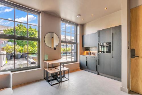 a kitchen with a table and a large window at Kings House Apartments in London