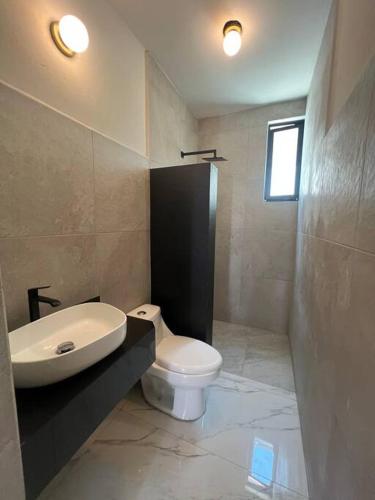a bathroom with a white toilet and a sink at Ejecutiva Frac privado Nueva alberca 50MB Factura in La Orilla