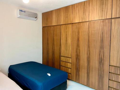 a bedroom with a blue ottoman next to a wooden cabinet at Ejecutiva Frac privado Nueva alberca 50MB Factura in La Orilla