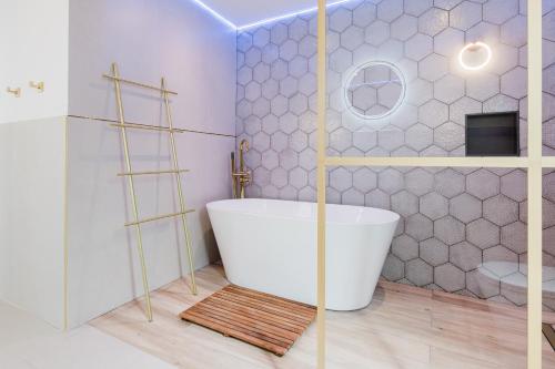 a bathroom with a white tub and a toilet at Palm Garden Valencia in Bétera