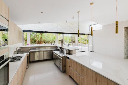 a large kitchen with white counters and a large window at Palm Garden Valencia in Bétera