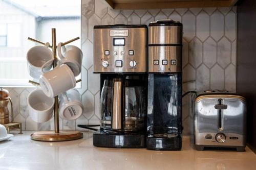 a coffeemaker sitting on top of a counter with cups at Snowbasin Summit Townhome in Morgan