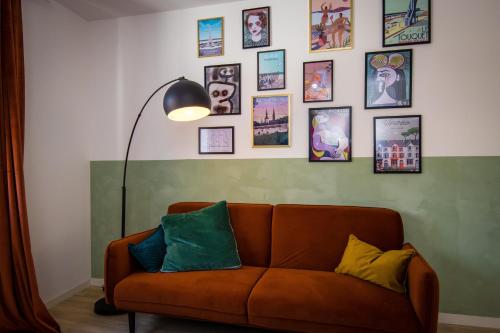 - un canapé dans le salon avec des photos sur le mur dans l'établissement Hesdin Appart Holidays 2, à Hesdin