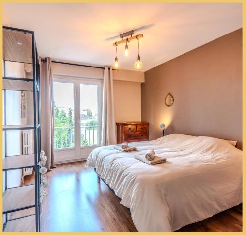 une chambre avec un grand lit et une grande fenêtre dans l'établissement Chez Lisa I T3 I Annemasse, à Annemasse
