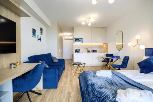 a living room with a blue couch and a kitchen at AboutArtApartments - Otyńska 4 in Wrocław