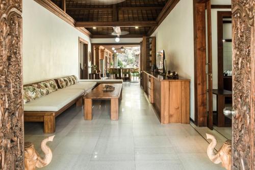 a living room with a couch and a table at Segara Beach House Villa - Kuta in Kuta