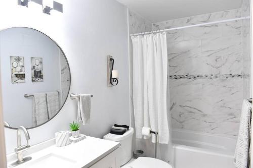 a white bathroom with a sink and a mirror at Heathers Hot tub Hideaway in Middle Grove