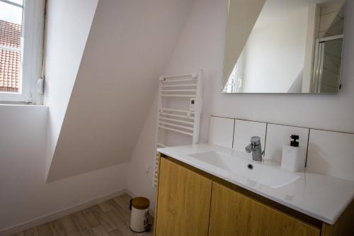 a bathroom with a sink and a mirror at Hesdin Appart Holidays 2 in Hesdin