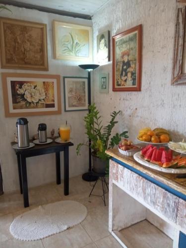 a kitchen with a table with a plate of fruit on it at Pousada Casa Jardim in Serra Negra