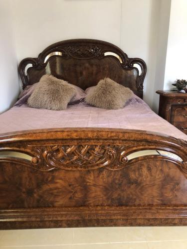 a large wooden bed with two pillows on it at Romana in Golubac