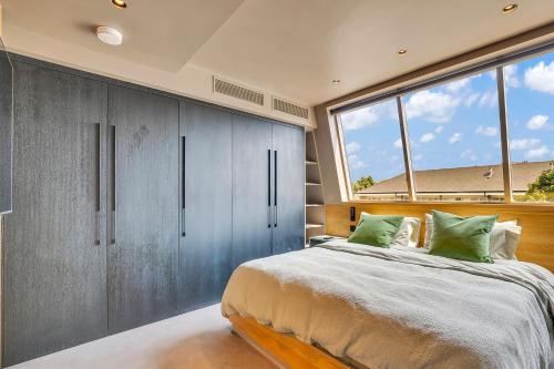 a bedroom with a large bed and large windows at Kings House Apartments in London