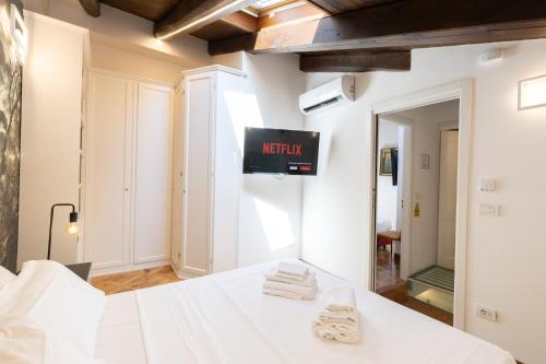 a bedroom with a bed with a tv on the wall at BolognaRoomscom - Isaia Garden Private Garden Spa Bath in Bologna