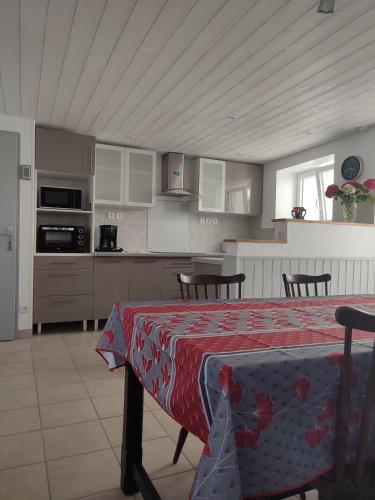 d'une cuisine avec une table et un chiffon rouge. dans l'établissement hortensia 8, à Saint-Étienne-de-Mer-Morte