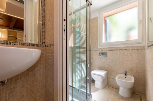 a bathroom with a toilet and a sink and a window at BolognaRoomscom - Isaia Garden Private Garden Spa Bath in Bologna
