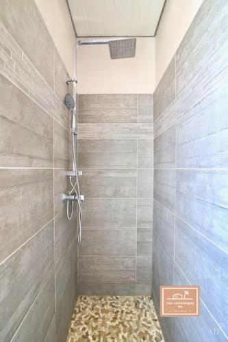 La salle de bains est pourvue d'une douche et d'un mur carrelé. dans l'établissement La Belle Bleu, piscine privée et centre ville, à La Seyne-sur-Mer