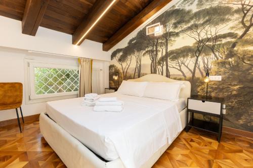 a bedroom with a white bed with a painting on the wall at BolognaRoomscom - Isaia Garden Private Garden Spa Bath in Bologna
