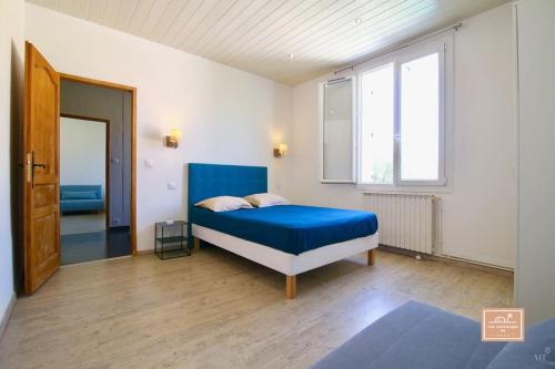 une chambre avec un lit bleu et une fenêtre dans l'établissement La Belle Bleu, piscine privée et centre ville, à La Seyne-sur-Mer