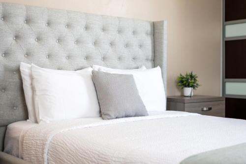 a bedroom with a white bed with a large headboard at La Mona Loiza Apartment Complex by Stay with Bear in San Juan