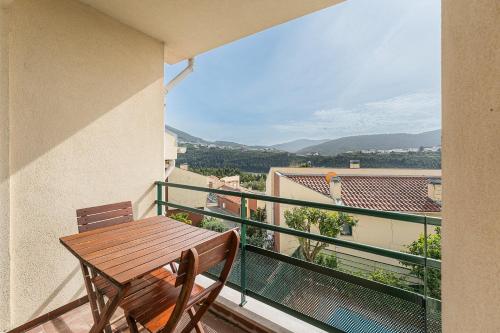 a wooden table and chairs on a balcony with a view at Relaxing time near the river in Penafiel