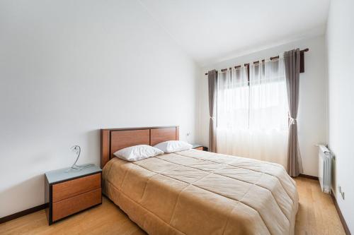 a bedroom with a large bed and a window at Relaxing time near the river in Penafiel