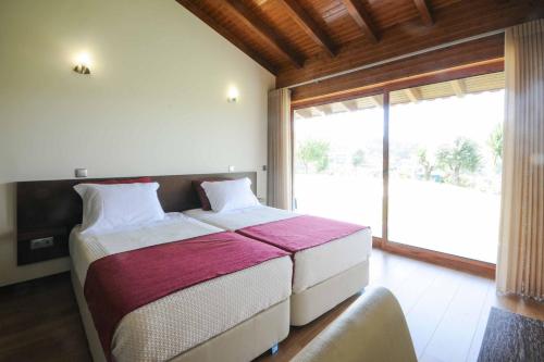 una camera da letto con un letto e una grande finestra di Casa da Pedra ad Aborim