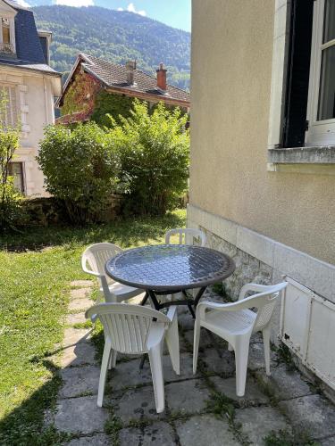 a table and chairs sitting next to a building at Villa Isabelle in Allevard