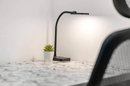 a lamp sitting on a table next to a potted plant at 10Guests! Parking 2ND FLOOR-Duplex in Fair Lawn