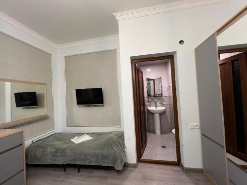 a room with a bed and a sink and a mirror at COMFORT M Guest House in Goris