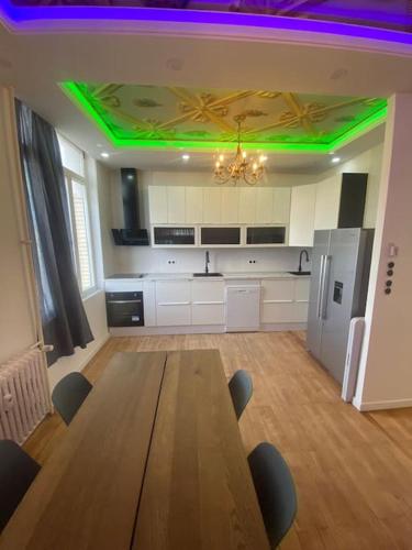 a large kitchen with a wooden table and green lights at Superbe appart au cœur d'Anvers in Antwerp