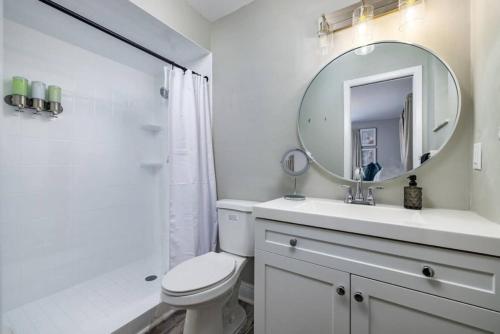 a white bathroom with a sink and a mirror at Spacious Family Oasis with Pool, BBQ, and Fire Pit in Seminole