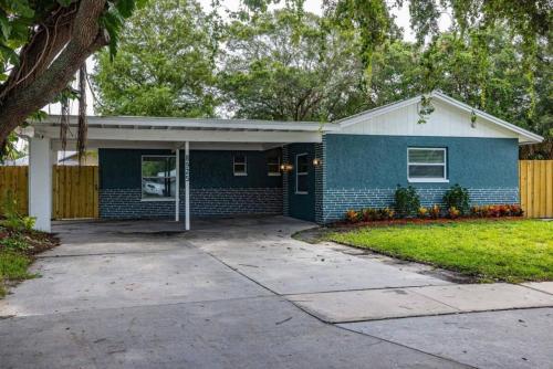 a blue house with a fence and a driveway at Spacious Family Oasis with Pool, BBQ, and Fire Pit in Seminole