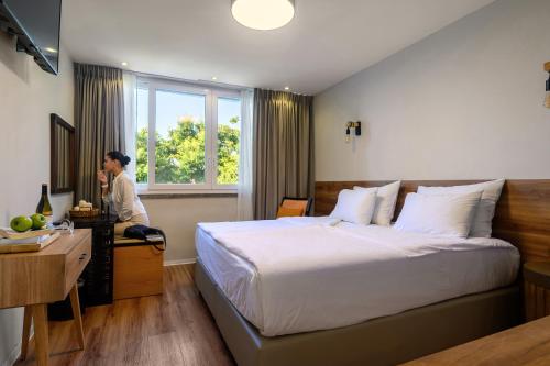 a man talking on a phone in a hotel room at Hotel Beit Maimon in Zikhron Ya‘aqov