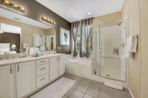 Un baño con dos lavabos y una ducha. en Serene Private Pool - Jacuzzi - BBQ - Gated Community, en Indio
