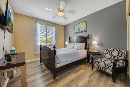 1 dormitorio con 1 cama, ventilador y silla en Serene Private Pool - Jacuzzi - BBQ - Gated Community, en Indio