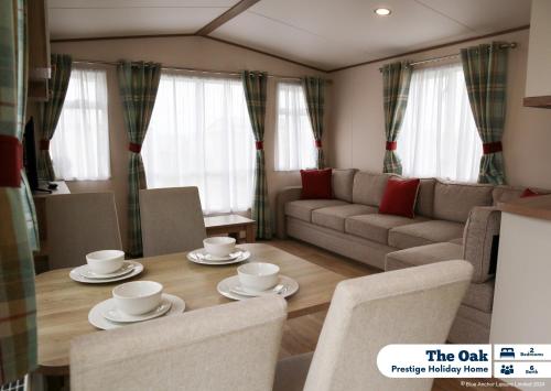 a living room with a table and chairs and a couch at Golden Palm Resort in Chapel Saint Leonards