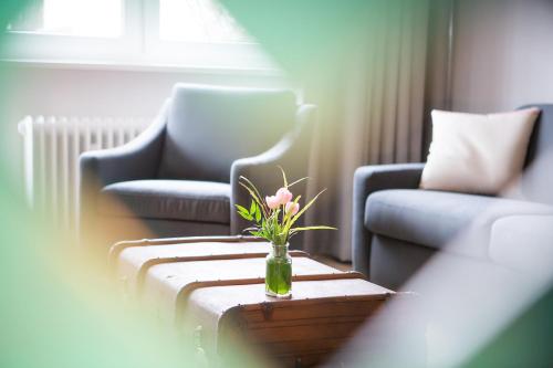 a vase of flowers on a table in a living room at Anna 1908 in Berlin