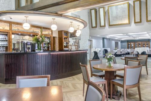 a restaurant with tables and chairs and a bar at Fota Island Hotel and Spa in Fota Island