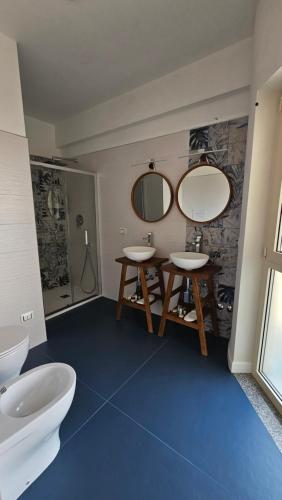 a bathroom with two sinks and a mirror at EKOA comfort e relax in San Nicola Arcella
