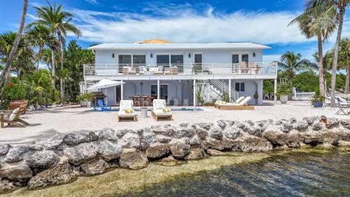 a white house on the shore of a body of water at Villa Jekjak in Cudjoe Key