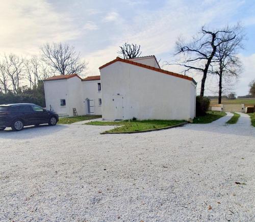a car parked in front of a white building at Calme Jardin & Parking prox Royan Appart 2 in Médis
