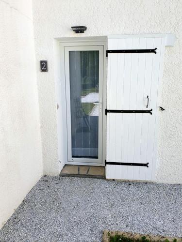 a white door with a glass window in a building at Calme Jardin & Parking prox Royan Appart 2 in Médis