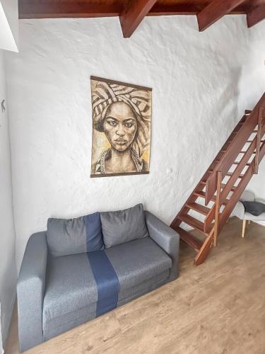 a living room with a couch and a painting on the wall at Duplex au vert près de Royan - Appartement 4 in Médis